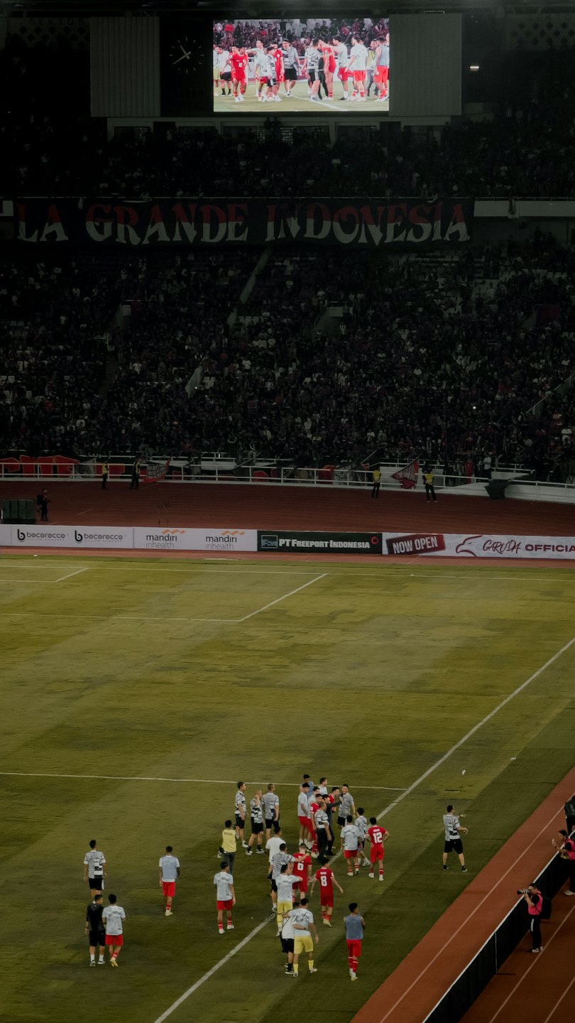 Football players compete on the field during a stadium game.